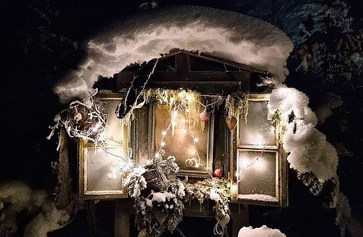 Weihnachtlich geschmücktes und beleuchtetes Fenster 