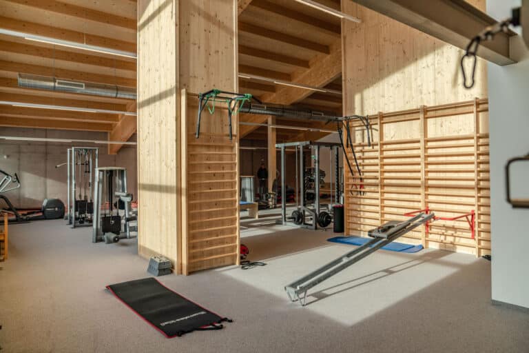 Fitnessraum mit Sprossenwand, Ellipsentrainer, Kraftstation und Trainingsgeräten für den Sport
